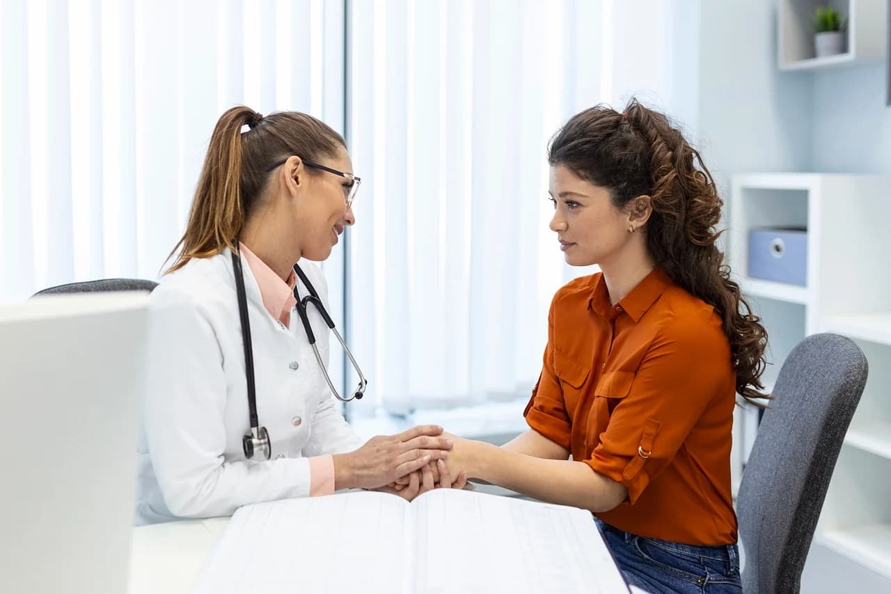 A doctor speaking to a young woman warmly